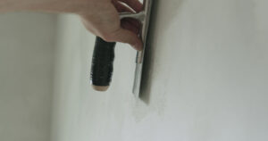 closeup worker doing drywall repair in home