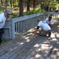 Three men working on a deck.