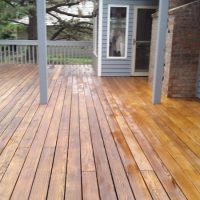 A refinished deck on a blue house.